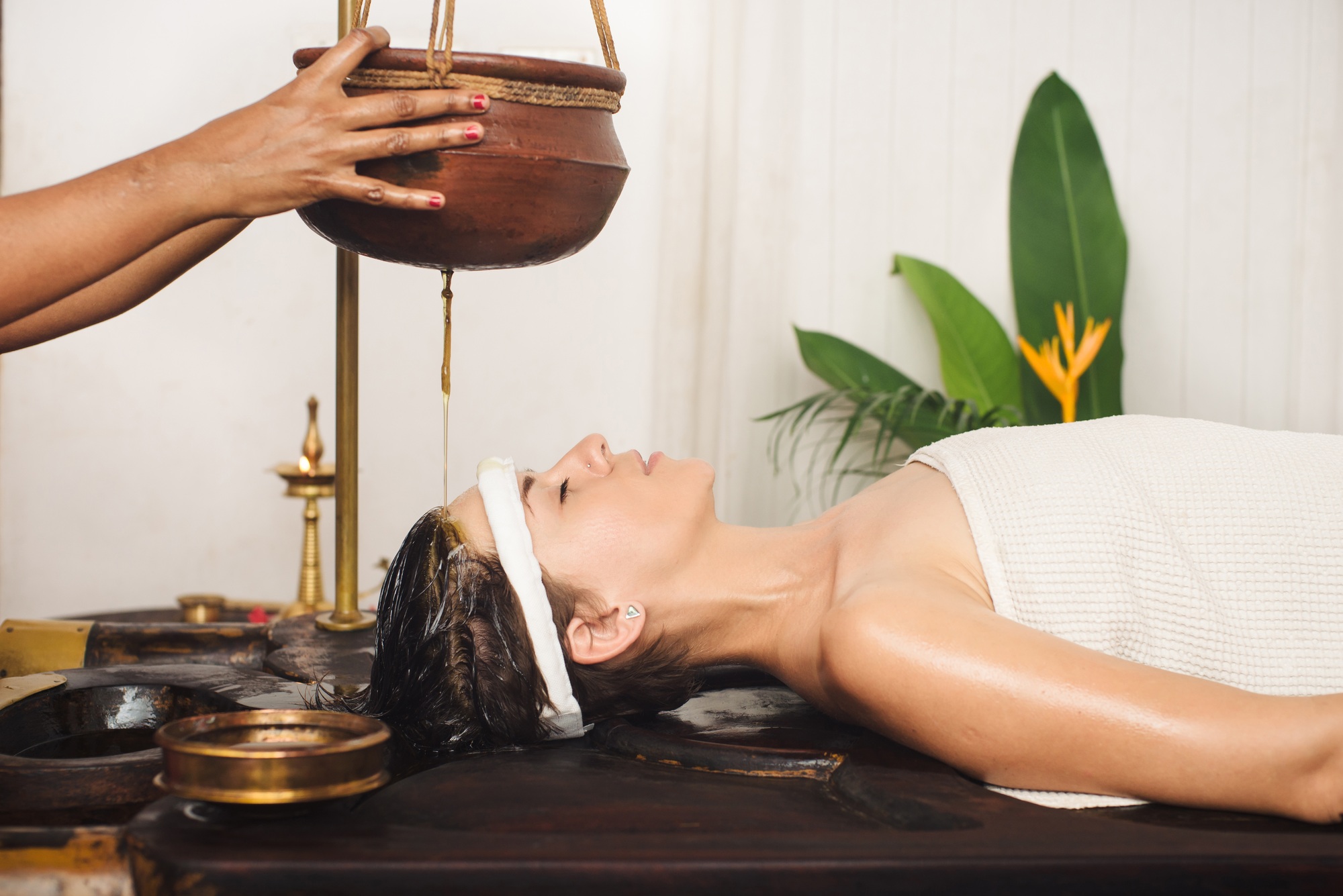 Caucasian woman having Ayurveda shirodhara treatment in India