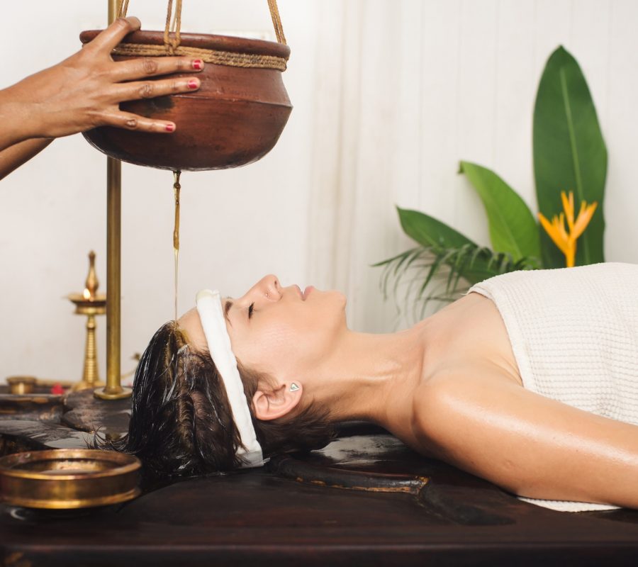 Caucasian woman having Ayurveda shirodhara treatment in India
